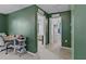 Green bedroom features adjacent room, desk with rolling cart, and access to the hallway at 7901 Iceland Gull St, Winter Garden, FL 34787