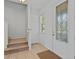 Inviting foyer featuring tiled floors, a decorative front door and nearby staircase at 7901 Iceland Gull St, Winter Garden, FL 34787