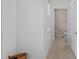 Hallway with tan tile floors leads to a half bathroom with a toilet and vanity at 7901 Iceland Gull St, Winter Garden, FL 34787