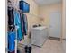 Bright laundry room featuring modern washer and dryer, wire shelving, and tile flooring at 7901 Iceland Gull St, Winter Garden, FL 34787