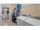Spacious laundry room with modern washer and dryer, wire shelving, and tile flooring at 7901 Iceland Gull St, Winter Garden, FL 34787
