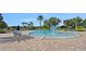 Large community pool with zero entry, splash fountain, deck chairs, and lush landscaping at 7901 Iceland Gull St, Winter Garden, FL 34787