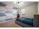 A modern bedroom features an accent wall and a comfortable bed with a window that provides natural light at 9153 Carmela Ave, Davenport, FL 33897