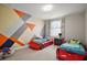 Unique ' bedroom features vibrant accent wall, light floors, and two race car-themed beds near a window at 9153 Carmela Ave, Davenport, FL 33897