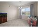 Bright dining room with modern chandelier, neutral walls, large window, and tile flooring offers plenty of space at 9153 Carmela Ave, Davenport, FL 33897