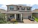 Charming two-story home with a well-manicured front yard and inviting covered entry at 9153 Carmela Ave, Davenport, FL 33897