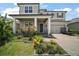 Charming two-story home featuring a well-manicured lawn, covered porch, and attached two-car garage at 9153 Carmela Ave, Davenport, FL 33897