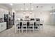 View of kitchen island with seating, modern appliances, and elegant pendant lighting at 9153 Carmela Ave, Davenport, FL 33897