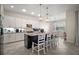 Bright kitchen featuring white cabinetry, a center island with seating and granite countertops at 9153 Carmela Ave, Davenport, FL 33897