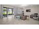 Spacious living room with tile flooring, modern furniture, and a sliding glass door to the patio at 9153 Carmela Ave, Davenport, FL 33897