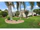 Well-manicured lawn and landscaping with palm trees surround this home's backyard, creating a serene outdoor living space at 953 Mayo Ct, The Villages, FL 32162