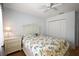 Neutral bedroom featuring a floral comforter, white furniture, and a double door closet at 953 Mayo Ct, The Villages, FL 32162