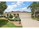Charming single-story home with a well-manicured lawn, mature landscaping, and a two-car garage at 953 Mayo Ct, The Villages, FL 32162