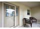 Inviting front porch with seating area, featuring a storm door and glass accent door at 953 Mayo Ct, The Villages, FL 32162