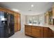 Bright kitchen with stainless steel appliances, wood cabinets, and a large black refrigerator at 953 Mayo Ct, The Villages, FL 32162