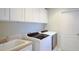Well-equipped laundry room featuring modern washer and dryer appliances and ample cabinet space at 953 Mayo Ct, The Villages, FL 32162
