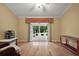 Bright living room with French doors leading to the lanai, hardwood floors, and comfortable seating at 953 Mayo Ct, The Villages, FL 32162