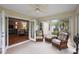 Inviting sunroom with rattan seating, tiled floors, and French door entry at 953 Mayo Ct, The Villages, FL 32162