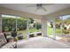 Charming sunroom with tiled floors and floor to ceiling windows that frame the green landscaping at 953 Mayo Ct, The Villages, FL 32162