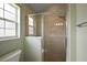 Modern shower with glass door, tiled walls, and convenient built-in shelving in the bathroom at 953 Mayo Ct, The Villages, FL 32162