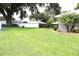 Expansive grassy backyard featuring a grand tree, surrounded by a white fence, offering privacy and tranquility at 1007 Cr 463B, Lake Panasoffkee, FL 33538
