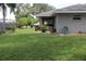 Spacious backyard featuring a manicured lawn, lush landscaping, and serene privacy at 1007 Cr 463B, Lake Panasoffkee, FL 33538
