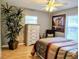 Bedroom with bed, dresser, hardwood floors, ceiling fan, and large potted plant at 1007 Cr 463B, Lake Panasoffkee, FL 33538