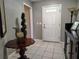 Tiled entryway featuring a white front door, classic table, and grey walls at 1007 Cr 463B, Lake Panasoffkee, FL 33538