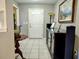 Bright entryway with white tiled floor, cabinet, and decorative table with lighting at 1007 Cr 463B, Lake Panasoffkee, FL 33538