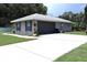 Single Gathering home with a gray exterior and a long driveway to the attached garage at 1007 Cr 463B, Lake Panasoffkee, FL 33538