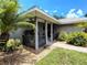 Inviting covered front porch with a seating area, potted plants, and decorative rock landscaping at 1007 Cr 463B, Lake Panasoffkee, FL 33538