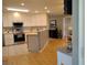 Open kitchen with white cabinets, stainless steel appliances, and a breakfast bar at 1007 Cr 463B, Lake Panasoffkee, FL 33538