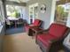 Enclosed patio featuring wicker furniture with red cushions and a dining area perfect for outdoor relaxation at 1007 Cr 463B, Lake Panasoffkee, FL 33538