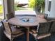 Covered patio with seating for four, offering a comfortable outdoor dining and relaxation area at 1007 Cr 463B, Lake Panasoffkee, FL 33538