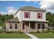 Charming two-story home featuring pink shutters and a welcoming covered front porch at 10288 Fiddley Aly, Orlando, FL 32827