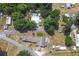 Aerial view showcasing the property and surrounding area, surrounded by lush greenery and neighboring homes at 1048 Cr 452A, Lake Panasoffkee, FL 33538
