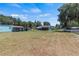 Expansive backyard featuring multiple structures on a large lot under a clear blue sky at 1048 Cr 452A, Lake Panasoffkee, FL 33538