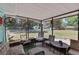 Relaxing screened porch with comfortable seating and views of the fenced backyard and lush greenery at 1048 Cr 452A, Lake Panasoffkee, FL 33538
