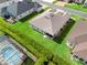 Aerial view of backyard with lush green lawn, manicured landscaping, and screened pool at 10927 Se 168Th Loop, Summerfield, FL 34491
