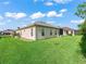 Well-maintained backyard with lush grass, a screened lanai and a home with stucco at 10927 Se 168Th Loop, Summerfield, FL 34491