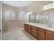Main bathroom features double vanities and arched shuttered windows for natural light at 10927 Se 168Th Loop, Summerfield, FL 34491