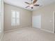 Bright bedroom features a ceiling fan, neutral walls, carpet flooring, and white window shutters at 10927 Se 168Th Loop, Summerfield, FL 34491