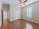 Well-lit bedroom with hardwood floors, a ceiling fan, closet, and plantation shutters at 10927 Se 168Th Loop, Summerfield, FL 34491