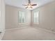 Bright carpeted bedroom featuring a ceiling fan and two windows with plantation shutters at 10927 Se 168Th Loop, Summerfield, FL 34491