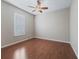 Neutral bedroom offers beautiful hardwood floors, a ceiling fan, and plantation shutters for privacy at 10927 Se 168Th Loop, Summerfield, FL 34491