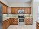 Modern kitchen with stainless appliances, granite counters, and wood cabinets at 10927 Se 168Th Loop, Summerfield, FL 34491