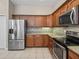 Well-equipped kitchen boasting stainless steel refrigerator and appliances, plus tile backsplash at 10927 Se 168Th Loop, Summerfield, FL 34491