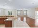 Open-concept living room featuring hardwood floors, natural light, and seamless flow to the kitchen area at 10927 Se 168Th Loop, Summerfield, FL 34491