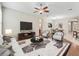 Bright, open-concept living room features stylish furniture, ceiling fan, and adjacent dining area at 10927 Se 168Th Loop, Summerfield, FL 34491