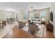 Stylishly furnished living room featuring hardwood floors, natural light, and an adjacent dining area at 10927 Se 168Th Loop, Summerfield, FL 34491